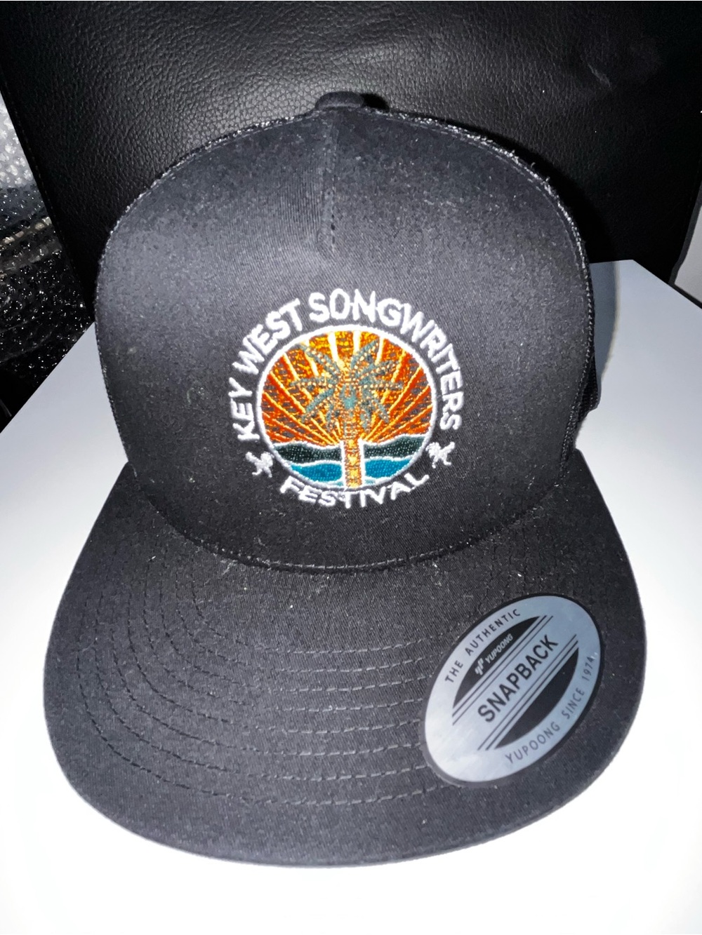 The Classic Black Snapback Hat with Orange and Blue Embroidered Logo